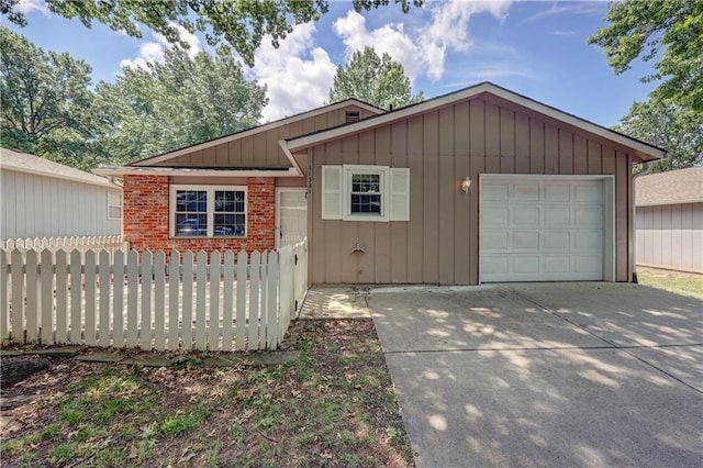 11321 W 77th Ter, Overland Park, KS 66214 - view of front of house with a garage, driveway, brick siding, and board and batten siding
