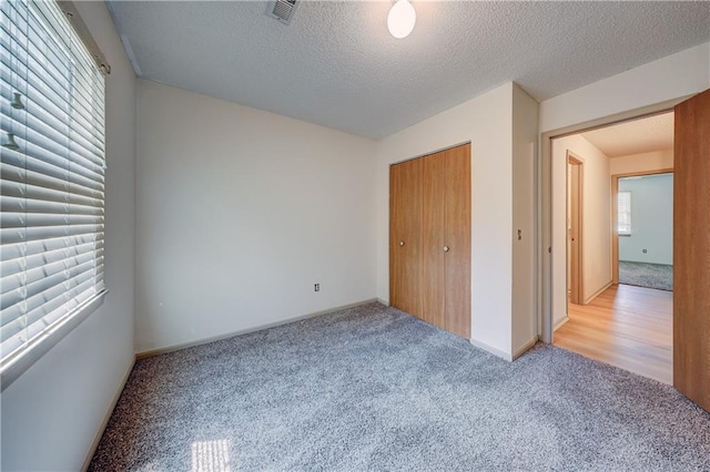 11321 W 77th Ter, Overland Park, KS 66214 - unfurnished bedroom with carpet flooring, a textured ceiling, and a closet