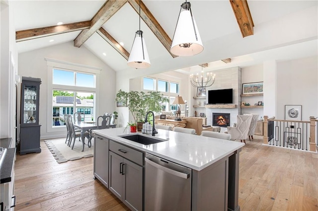 130 NW Ambersham Dr, Lees Summit, MO 64081 - kitchen with stainless steel dishwasher, gray cabinetry, beamed ceiling, healthy amount of natural light, and light wood-type flooring
