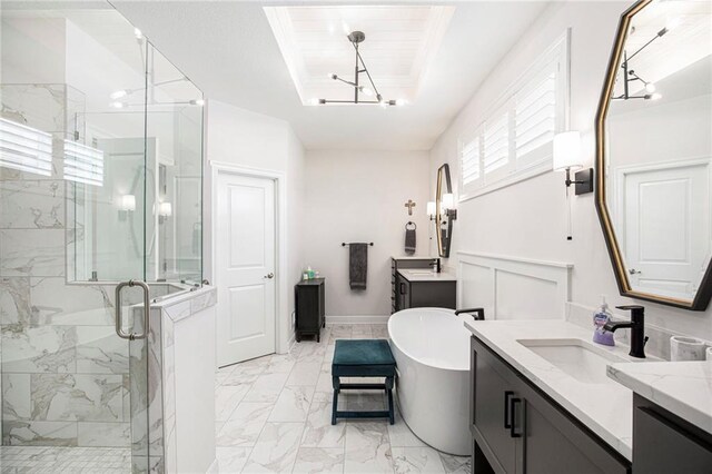 130 NW Ambersham Dr, Lees Summit, MO 64081 - bathroom with two vanities, a marble finish shower, a freestanding tub, marble look tile flooring, and a chandelier