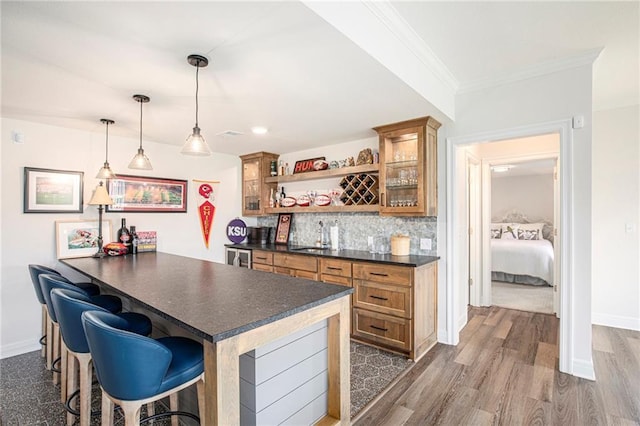 130 NW Ambersham Dr, Lees Summit, MO 64081 - indoor wet bar with dark wood-style floors, backsplash, crown molding, and pendant lighting