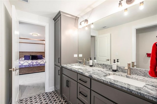 130 NW Ambersham Dr, Lees Summit, MO 64081 - ensuite bathroom featuring double vanity and baseboards