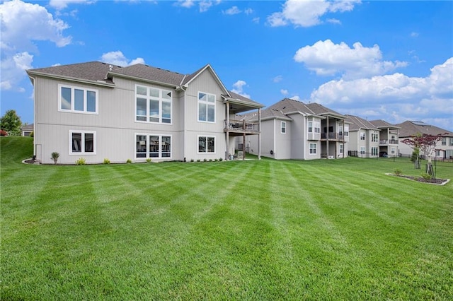 130 NW Ambersham Dr, Lees Summit, MO 64081 - rear view of property featuring a lawn, a residential view, and a balcony