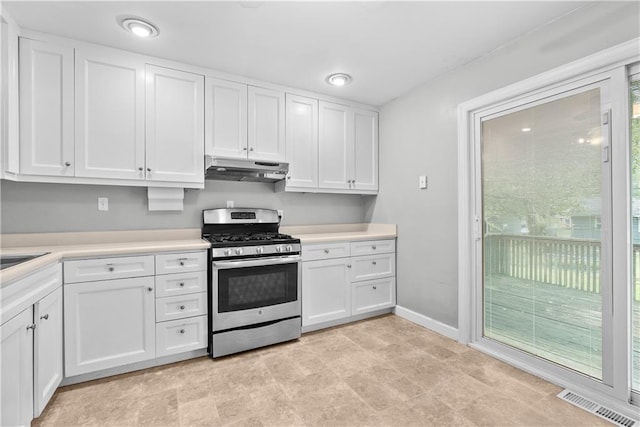 4510 E 113th St, Kansas City, MO 64137 - kitchen with stainless steel gas stove, under cabinet range hood, white cabinets, and light countertops
