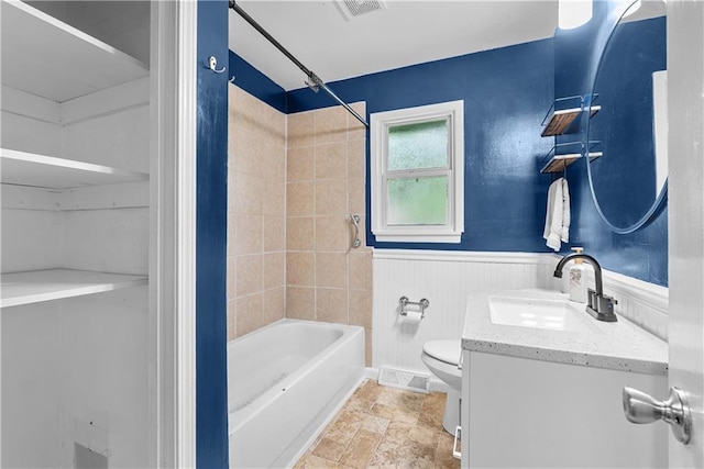 4510 E 113th St, Kansas City, MO 64137 - full bathroom with vanity, shower / bathtub combination, a wainscoted wall, and stone finish floors