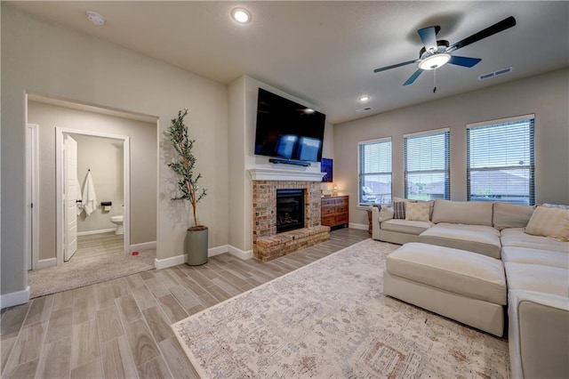 7526 Apache Dr, Lenexa, KS 66227 - living area featuring ceiling fan, a fireplace, light wood finished floors, and recessed lighting