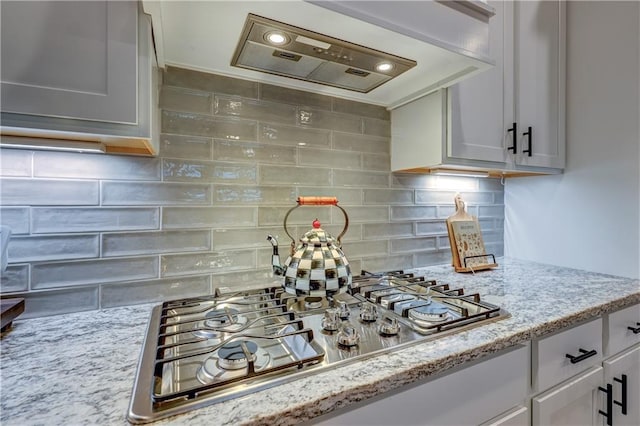 7526 Apache Dr, Lenexa, KS 66227 - kitchen featuring custom exhaust hood, stainless steel gas stovetop, decorative backsplash, and light stone countertops