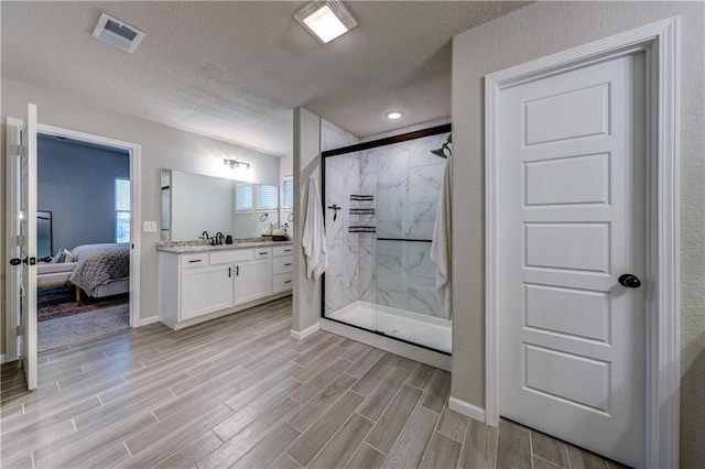 7526 Apache Dr, Lenexa, KS 66227 - ensuite bathroom with a marble finish shower, vanity, wood finished floors, and a textured ceiling