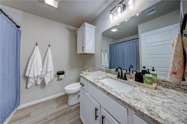 7526 Apache Dr, Lenexa, KS 66227 - bathroom with vanity, wood finished floors, curtained shower, and a textured ceiling