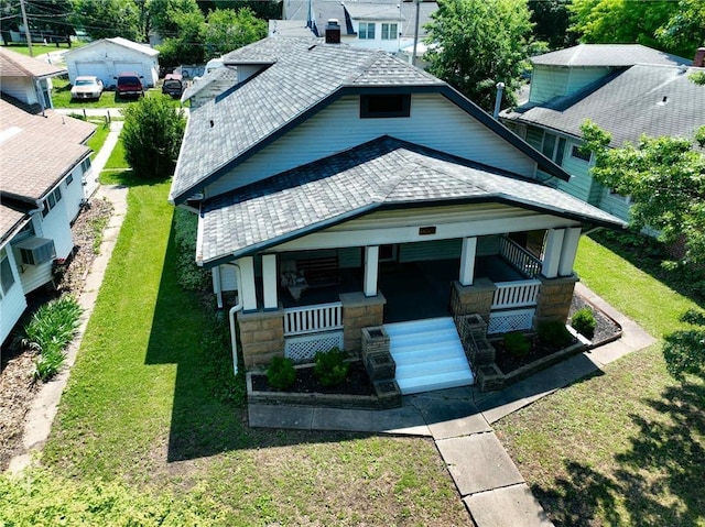 1208 Central Ave, Horton, KS 66439 - view of front of house with a porch, roof with shingles, stone siding, and a front lawn