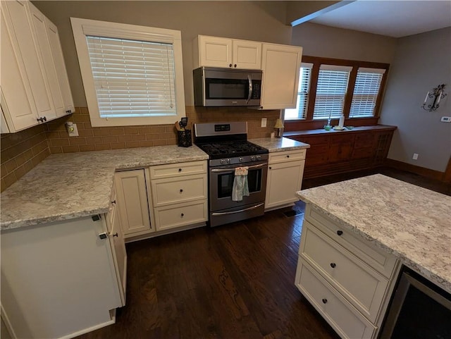 1208 Central Ave, Horton, KS 66439 - kitchen featuring appliances with stainless steel finishes, white cabinets, dark wood-type flooring, and backsplash