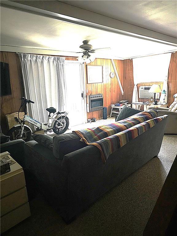 23664 Erickson Ln, Wheatland, MO 65779 - living area with ceiling fan, wooden walls, carpet floors, and cooling unit