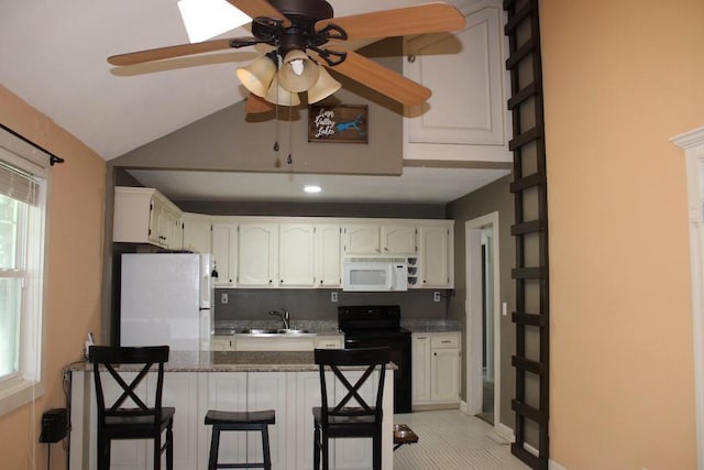 42 Driftwood Ln, Linn Valley, KS 66040 - kitchen featuring white appliances, a ceiling fan, white cabinets, a kitchen bar, and lofted ceiling