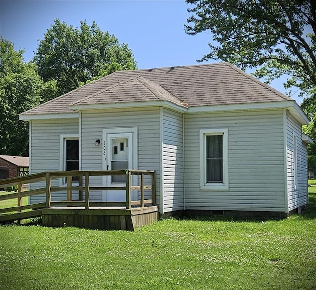 306 E Palmer St, Arma, KS 66712 - rear view of property featuring a deck, a lawn, and roof with shingles