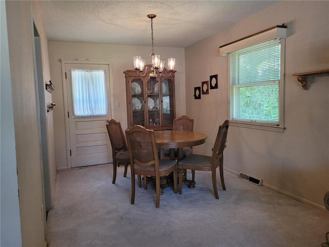 8603 E 85th St, Raytown, MO 64138 - dining space featuring a chandelier, carpet flooring, and a textured ceiling