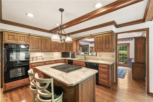 12600 Wenonga Ln, Leawood, KS 66209 - kitchen featuring black appliances, a kitchen island, crown molding, wood finished floors, and light stone counters