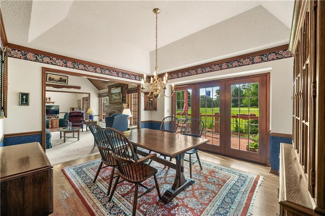 12600 Wenonga Ln, Leawood, KS 66209 - dining area with vaulted ceiling, french doors, a chandelier, light wood finished floors, and a textured ceiling