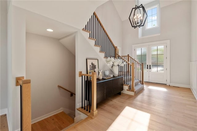 7106 Linden St, Prairie Village, KS 66208 - entryway featuring a chandelier, wood finished floors, high vaulted ceiling, and stairway