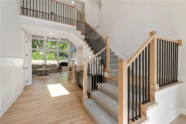 7106 Linden St, Prairie Village, KS 66208 - staircase with a high ceiling, wood finished floors, and a chandelier