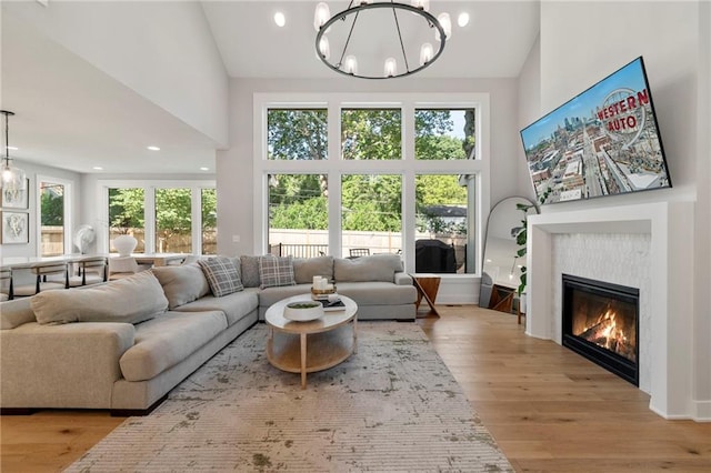 7106 Linden St, Prairie Village, KS 66208 - living area with high vaulted ceiling, a chandelier, wood finished floors, a glass covered fireplace, and recessed lighting