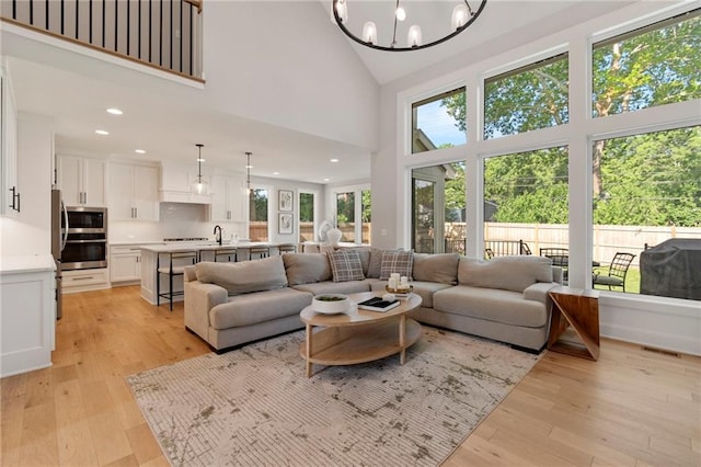 7106 Linden St, Prairie Village, KS 66208 - living room with a chandelier, high vaulted ceiling, light wood finished floors, and recessed lighting