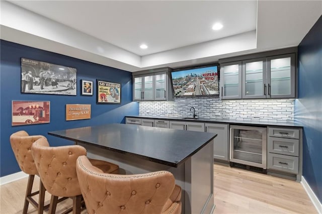 7106 Linden St, Prairie Village, KS 66208 - indoor wet bar with wine cooler, light wood-type flooring, decorative backsplash, recessed lighting, and a raised ceiling