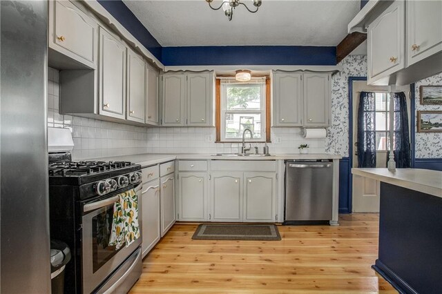 3920 S Milton Dr, Independence, MO 64055 - kitchen with stainless steel appliances, a sink, light countertops, and backsplash