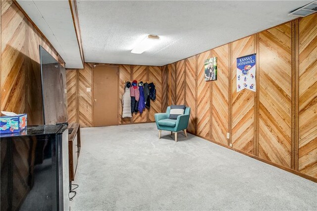 3920 S Milton Dr, Independence, MO 64055 - sitting room with carpet floors, wood walls, and a textured ceiling