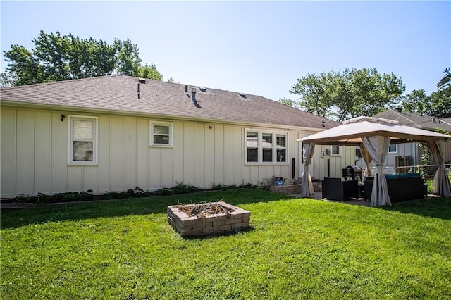 3920 S Milton Dr, Independence, MO 64055 - rear view of property featuring an outdoor fire pit, a gazebo, a lawn, and a shingled roof