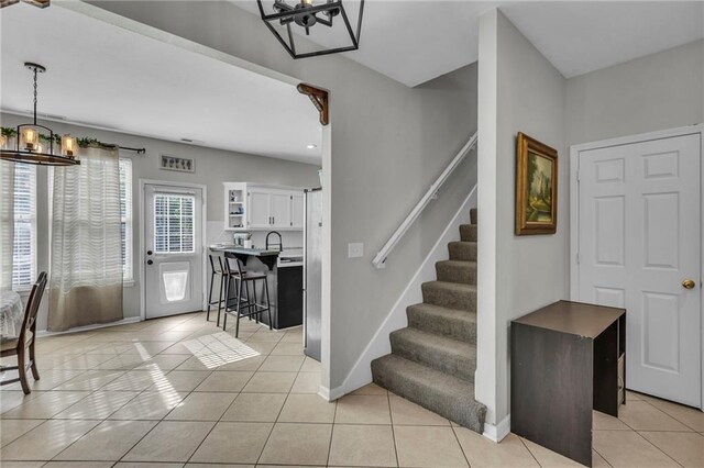 408 Eisenhower Rd, Baldwin City, KS 66006 - foyer entrance featuring a chandelier, light tile patterned flooring, stairs, and recessed lighting
