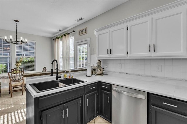 408 Eisenhower Rd, Baldwin City, KS 66006 - kitchen featuring dishwasher, light tile patterned flooring, white cabinets, a chandelier, and decorative backsplash