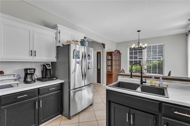 408 Eisenhower Rd, Baldwin City, KS 66006 - kitchen featuring freestanding refrigerator, white cabinets, a chandelier, light countertops, and light tile patterned floors