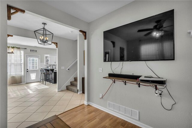 408 Eisenhower Rd, Baldwin City, KS 66006 - interior space with stairway, light tile patterned floors, and a chandelier