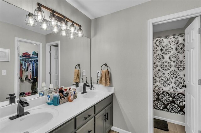 408 Eisenhower Rd, Baldwin City, KS 66006 - full bath featuring double vanity, a spacious closet, and wood finished floors