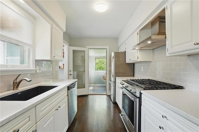 8146 Craig St, Overland Park, KS 66204 - kitchen featuring wall chimney exhaust hood, stainless steel appliances, white cabinetry, and tasteful backsplash