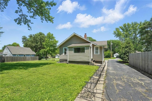 8146 Craig St, Overland Park, KS 66204 - back of house featuring a chimney and asphalt driveway