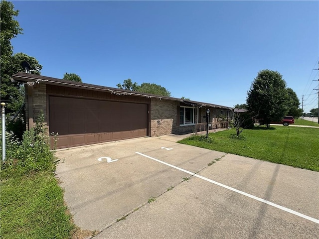 1110 S Plummer Ave, Chanute, KS 66720 - ranch-style house with a front yard, a garage, brick siding, and driveway