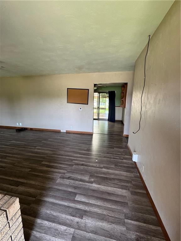 1110 S Plummer Ave, Chanute, KS 66720 - unfurnished room featuring wood finished floors and baseboards