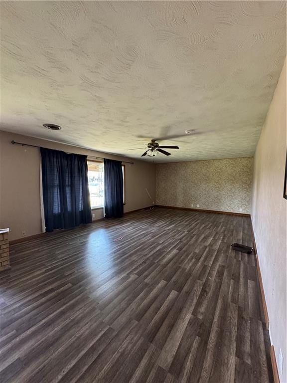 1110 S Plummer Ave, Chanute, KS 66720 - spare room with dark wood-type flooring, ceiling fan, a textured ceiling, and baseboards