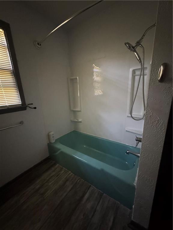 1110 S Plummer Ave, Chanute, KS 66720 - full bathroom with bathtub / shower combination and wood finished floors