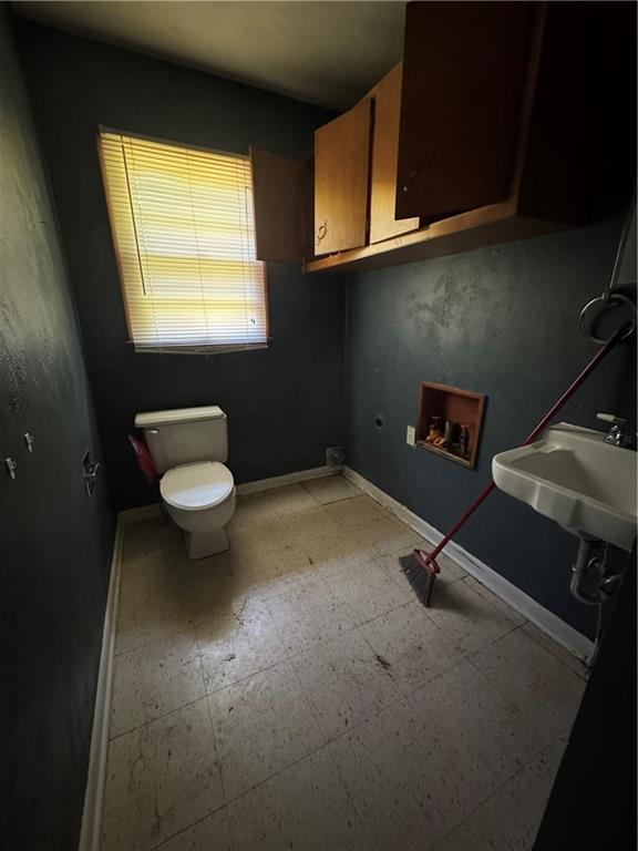 1110 S Plummer Ave, Chanute, KS 66720 - bathroom with toilet, a sink, and baseboards
