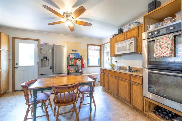 1401 Osage St, Leavenworth, KS 66048 - kitchen featuring appliances with stainless steel finishes, brown cabinets, a ceiling fan, and light countertops