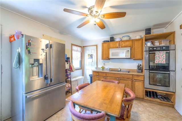 1401 Osage St, Leavenworth, KS 66048 - kitchen featuring appliances with stainless steel finishes, brown cabinets, a ceiling fan, light countertops, and crown molding