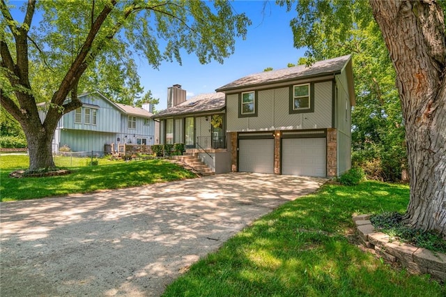 4612 Locust Ave, Kansas City, KS 66106 - split level home with an attached garage, concrete driveway, a front yard, and a chimney