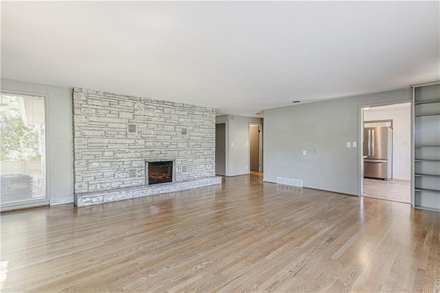12600 Brooklyn St, Kansas City, MO 64146 - unfurnished living room with light wood-style floors and a fireplace