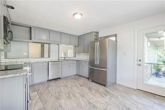 12600 Brooklyn St, Kansas City, MO 64146 - kitchen with stainless steel appliances, gray cabinets, tasteful backsplash, open shelves, and a textured ceiling