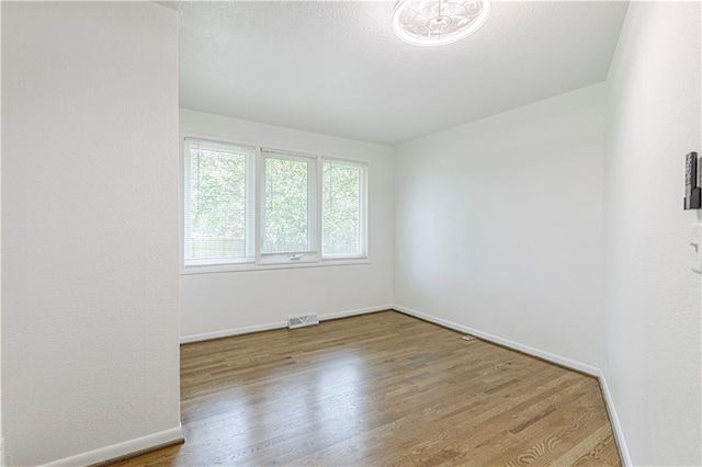 12600 Brooklyn St, Kansas City, MO 64146 - unfurnished room with wood finished floors and a textured ceiling
