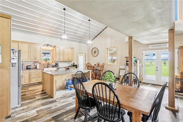 301 NW 1601st Rd, Kingsville, MO 64061 - dining space with vaulted ceiling, light wood-type flooring, a textured ceiling, and french doors