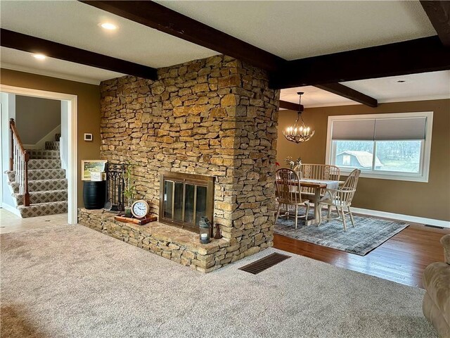 26609 S Red Bud Rd, Freeman, MO 64746 - carpeted living area with stairway, beam ceiling, a stone fireplace, and a chandelier