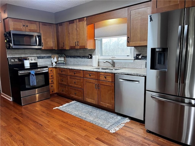 26609 S Red Bud Rd, Freeman, MO 64746 - kitchen with stainless steel appliances, backsplash, wood finished floors, and a textured ceiling